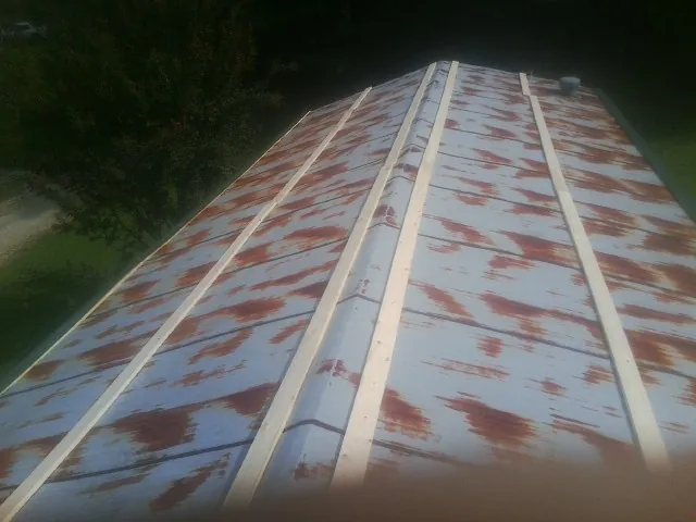 Rusted metal roof panels with new wood purlins before replacement — Storm Damage Roof Repair in Aydlett by Roofing Brothers